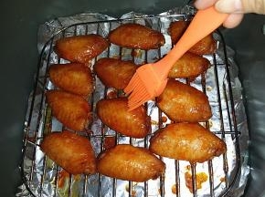 过8分钟后再取出，看颜色已明显变深了，此时翻面刷层蜂蜜水 

（PS：刷蜂蜜水让烤好的鸡翅表面透亮微甜更好吃、当然不刷也是可以的）