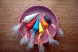 将糖霜分成6份，其中一份加入黑色素，拌均匀，用于绘轮廓。四份分别加入色素调色，用鲜柠檬汁调节浓稠度，填色糖霜是滴落后两三秒左右消失纹路的状态即可。余下的一份白色糖霜，只加入适量的柠檬汁调稀成为填色糖霜。