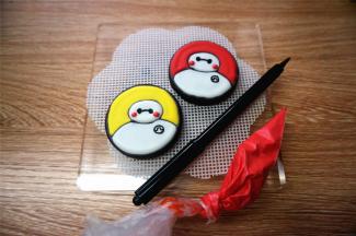 用食用色素笔画出细节部分，如眼睛，胸口的小标记。最后用红色糖霜点上小脸蛋，晾干即可。