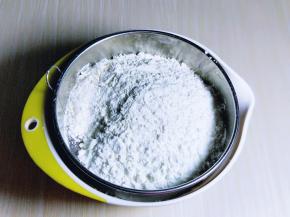 低筋面粉与甘汁园淀粉混合在细筛里，筛入黄油器具中。