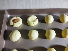 用大拇指轻轻按压，无需太用力。避免中间太薄，看出来的饼干容易断裂，放上杏仁再轻轻按压。（一定要用大拇指，按力要均匀，这样才漂亮）