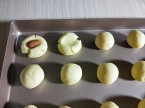 用大拇指轻轻按压，无需太用力。避免中间太薄，看出来的饼干容易断裂，放上杏仁再轻轻按压。（一定要用大拇指，按力要均匀，这样才漂亮）