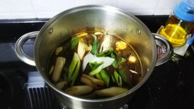 倒入水、酱油、大葱段、冰糖煮开