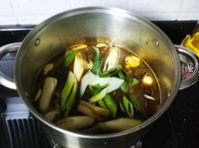 倒入水、酱油、大葱段、冰糖煮开