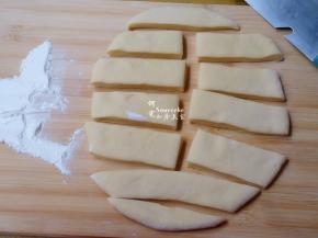 擀好的面团，用刀切成长方形条。最好能把面团擀成长条形或正方形，我的擀成了椭圆形，切的时候就会有边角。