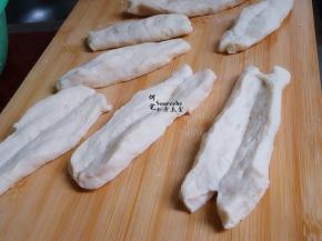 用刀切好的面皮，再从中间划一刀，不能断，也可以用筷子中从中间按压。两头不能黏在一起，中间不能断开。这样炸的油条膨胀松软。