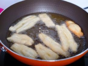 热锅，倒入适量的油，油温到达180度左右，放入油条胚，油条会迅速膨胀。