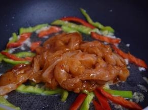 再加入腌制好的鸡肉，大火翻炒至变白