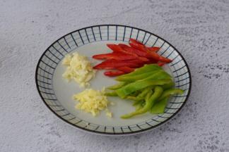 青椒去籽洗净切成条状，红椒去籽洗净切成条状，姜切末，蒜切末