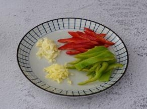 青椒去籽洗净切成条状，红椒去籽洗净切成条状，姜切末，蒜切末