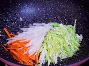 原锅倒入适量的食用油烧热，再放入胡萝卜、白萝卜、包菜翻炒至变软
