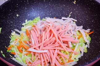 再加入火腿肠、肉卷翻炒断生
