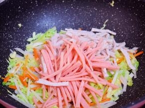 再加入火腿肠、肉卷翻炒断生
