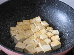 锅热后倒入适量玉米胚芽油，放入豆腐块煎至两面金黄，期间记得翻面;