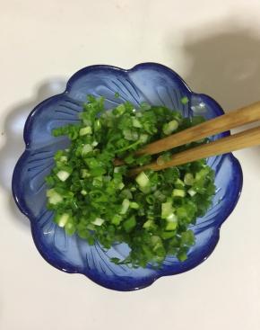 小葱切成葱花，淋入适量的油拌匀，可以保持葱的绿色。