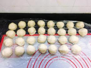 开始包酥，取1份水油皮按扁，在水油皮最中间的位置放入1份油酥，用虎口往上推水油皮，完全裹住油酥后收口，收口一定要收紧，依次全部包好。