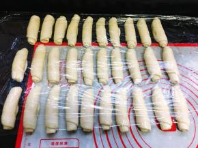 从上往下卷起来，卷成1个圆柱体，依次全部卷好，盖上保鲜膜松弛15分钟。