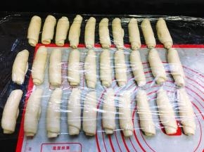 从上往下卷起来，卷成1个圆柱体，依次全部卷好，盖上保鲜膜松弛15分钟。