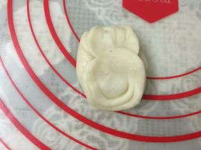 松弛好后，取1份收口朝上，将拇指放在圆柱的中间按一下，然后将两端向中间捏起。