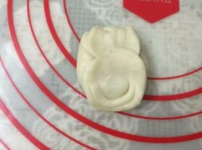 松弛好后，取1份收口朝上，将拇指放在圆柱的中间按一下，然后将两端向中间捏起。