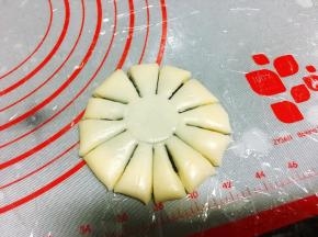 收口向下，压扁成大饼状，一定要扁一些，太厚不好看，用一个矿泉水瓶盖在中间轻轻压出一个圆印，接着用小刀平均分割成12份，可以先1分为4，然后在每1份里割上均等大小的两刀。