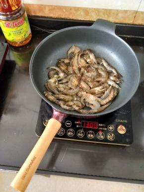 然后倒入处理干净的虾，翻炒均匀。