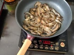 然后倒入处理干净的虾，翻炒均匀。