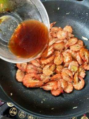 待虾全部煎至金黄后倒入事先准备好的料汁，小火焖片刻。