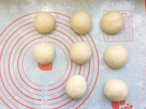 取出发酵好的面团，轻拍排气后将面团称重，用刮板分成8个均等的小面团，将面团滚圆后盖上保鲜膜松弛20分钟。
