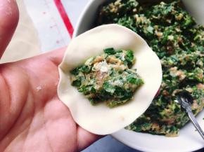 然后在面皮中间包入适量的韭菜猪肉馅，用手捏紧成饺子状。