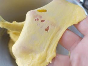 10分钟左右可以拉出这样的薄膜，放入黄油和盐，继续揉面。