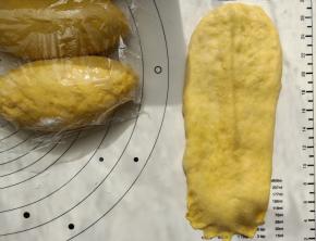 再进行二次擀卷，同样擀成牛舌形再卷起来。