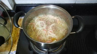 加入蟹棒条、牛肉碎，用汤勺打散，慢慢继续煮10分钟