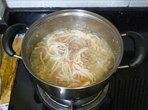 加入蟹棒条、牛肉碎，用汤勺打散，慢慢继续煮10分钟
