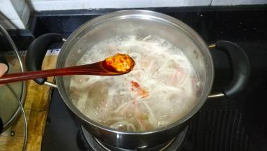 放入2勺蟹黄酱一边搅拌一边加盐调好味道，关火
