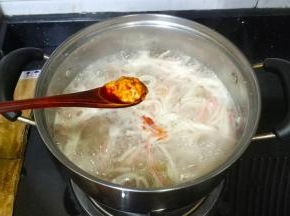 放入2勺蟹黄酱一边搅拌一边加盐调好味道，关火
