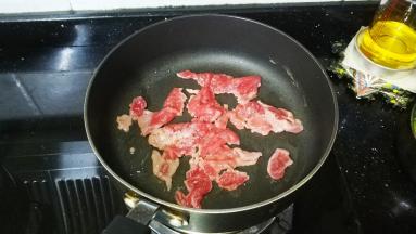 锅里热油，放入牛肉片煎熟