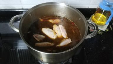 卤汁全部倒入锅里大火烧5分钟再放入鸡脚、鸡翅、冰糖