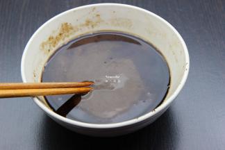 接下来我们来做广东凉粉，把仙草粉倒入碗里，加适量的冷水拌均成糊，无核的糊状即可。一般100克仙草粉，用2碗水拌均。