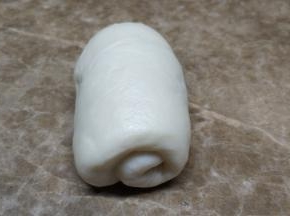 将鬆弛好的麵糰分别擀成长椭圆形，两边向中间叠起擀平，由上至下卷起来