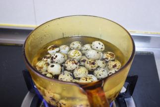 鹌鹑蛋洗净后放锅中煮，大火烧开后转小火继续煮三四分钟，取出来放凉水中冲凉，把皮扒掉