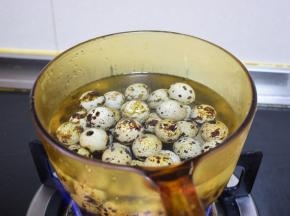 鹌鹑蛋洗净后放锅中煮，大火烧开后转小火继续煮三四分钟，取出来放凉水中冲凉，把皮扒掉