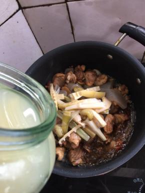 加入适量的酸笋，顺便把腌制酸笋的水也倒一点儿进去翻炒均匀。