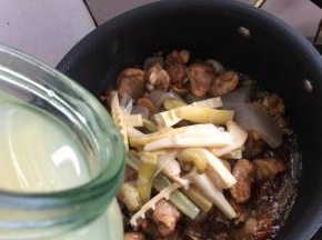 加入适量的酸笋，顺便把腌制酸笋的水也倒一点儿进去翻炒均匀。