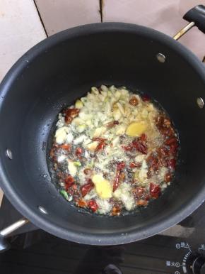 锅烧热倒入适量的油，放入生姜，蒜瓣，花椒，干辣椒爆香。