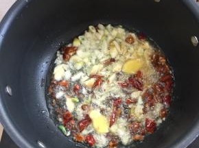 锅烧热倒入适量的油，放入生姜，蒜瓣，花椒，干辣椒爆香。