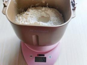 加入全脂奶粉,鸡蛋,奶粉,玉米油,加入高筋面粉,让面粉覆盖整个水面,面粉的顶端挖个小洞,加入酵母粉,再用旁边面粉把酵母粉盖起来!