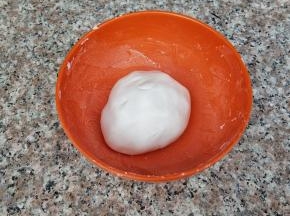先开始制作糯米圆子，糯米粉放入碗中，加入温水，合成团