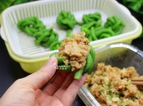 猪瘦肉洗净，剁碎，放盐、油、生抽、生粉、生姜、香葱拌均，然后把肉酿入卷好的豆角里。