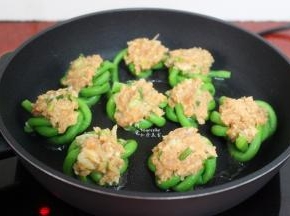 热锅，倒油，放入酿好的豆角，豆角朝下，有肉的一面朝上。中小火煎至肉六成熟，可以凝固不散。
